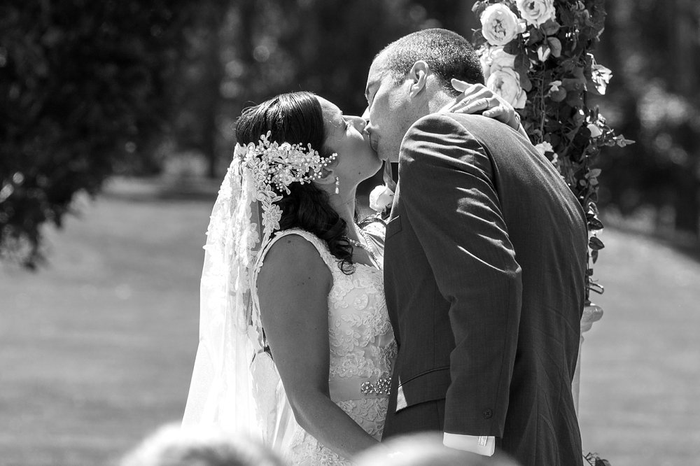 bride and groom having first kiss photo at Rosemount Estate Wedding Venue in Ohoka