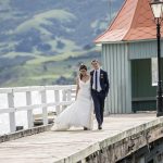 Akaroa wedding photographer with the bride and groom at the harbour