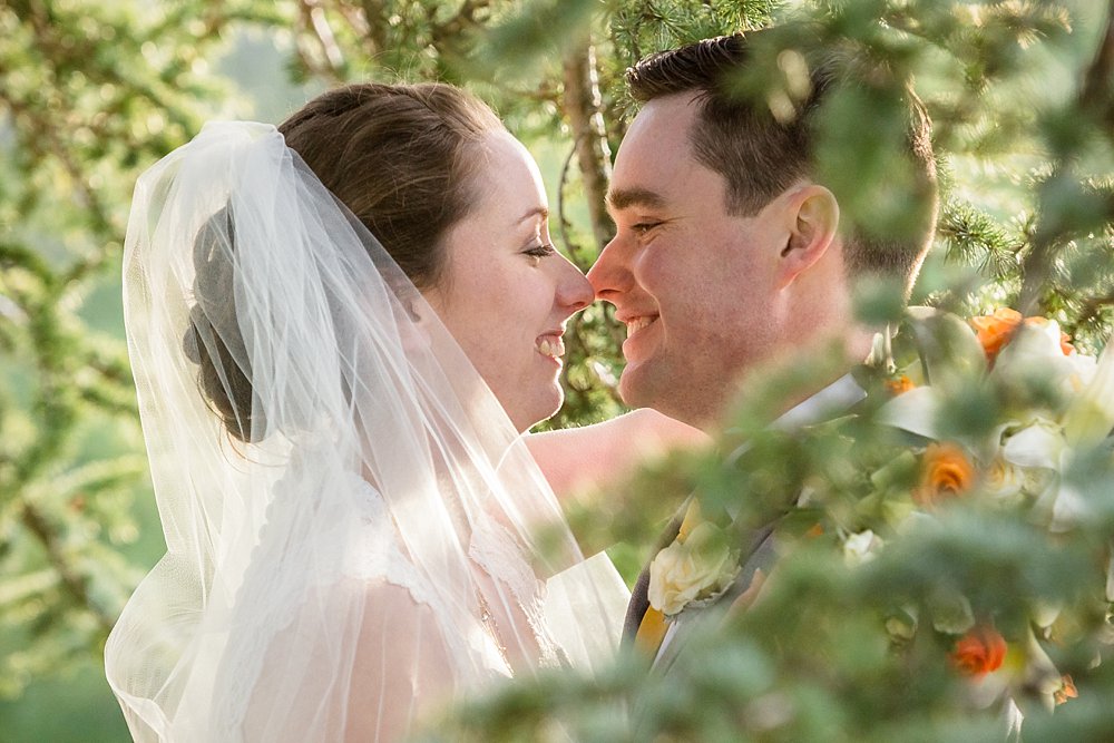 close up of Bride and groom captured through foliage by Christchurch Wedding Photographer