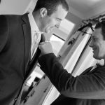 Wedding photo of the best man fixing the groom's pocket square