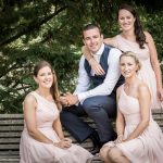 groom poses for a photograph with the bridesmaids