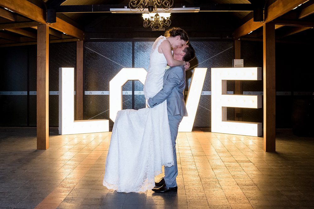 groom lifting-kissing bride on dance floor-Wedding Photographers Christchurch