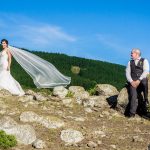 Christchurch wedding photographer capture of the bride and groom up on top of a hill with the bride's veil being caught in the wind