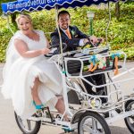 Hanmer wedding photographer image of bride and groom having fun riding a two seater bike on there wedding day