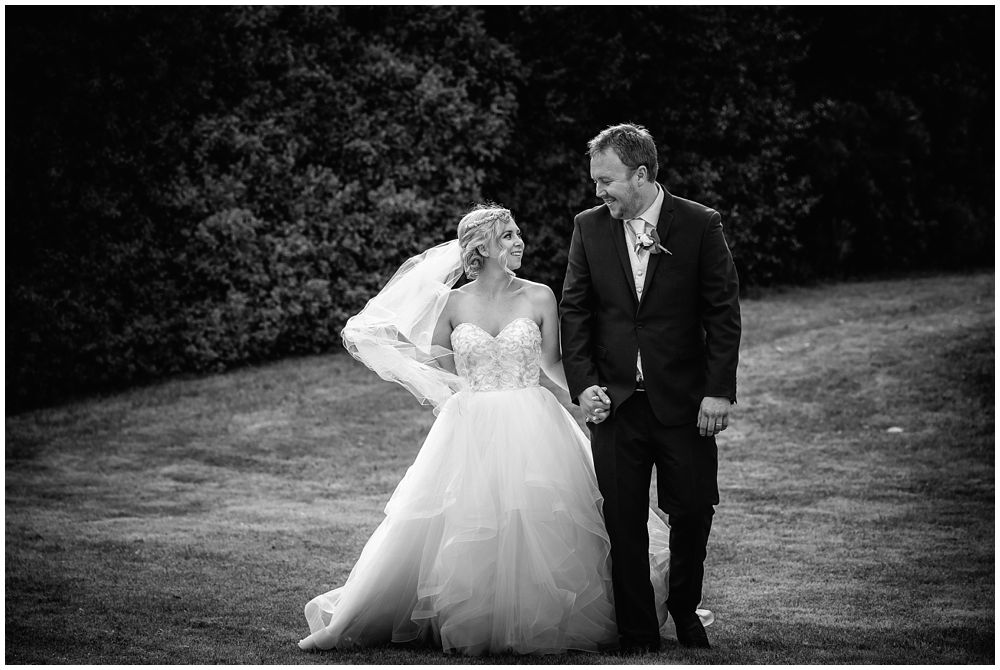 Bride and groom walk on the lawn