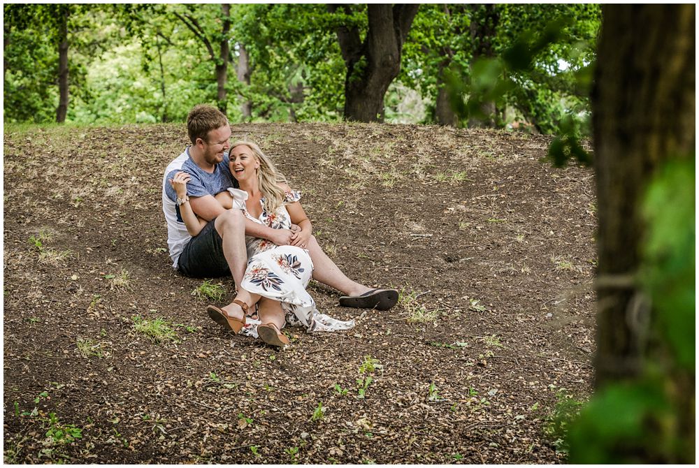 Kaiapoi domain engagement photography with couple sitting on the ground