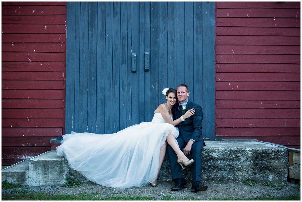 bride-groom sitting infant of barn at Tipapa Woolshed Barn Wedding Venue