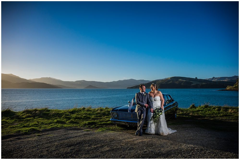 bride and groom with car and sea vista