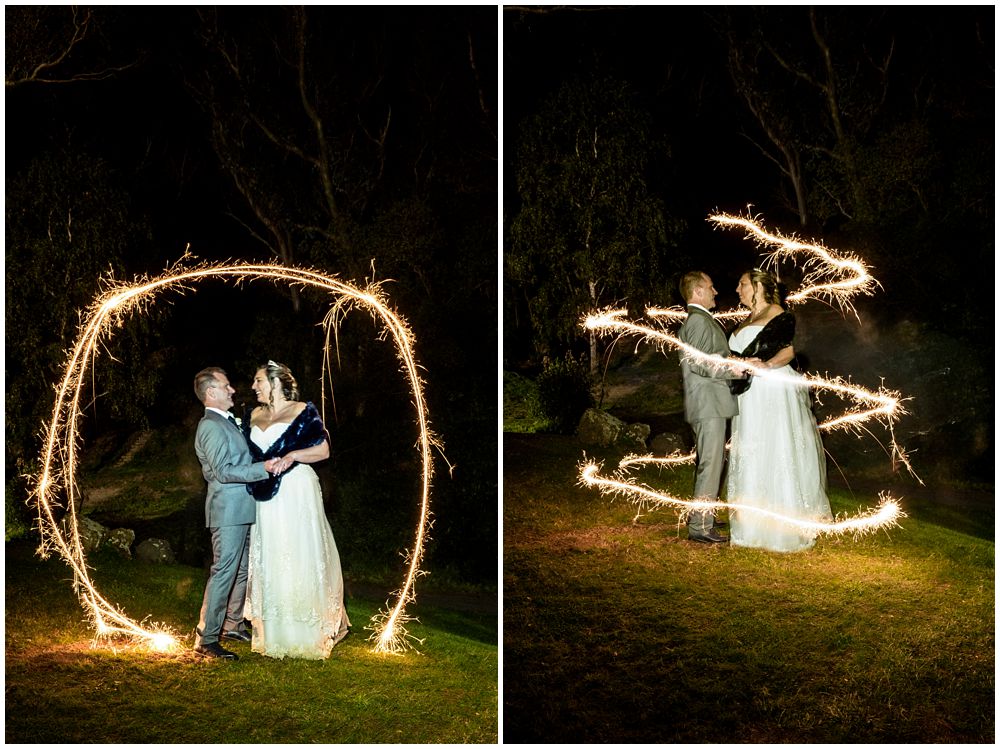 bride and groom pose for sparkler photo