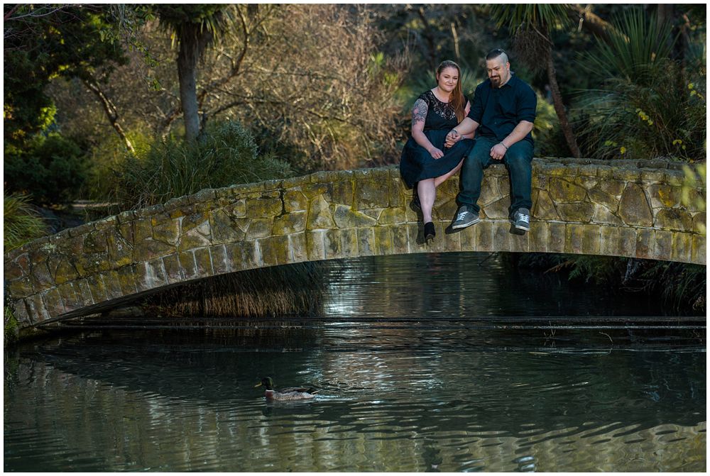 Engaged couple relaxing on a bridge in gardens