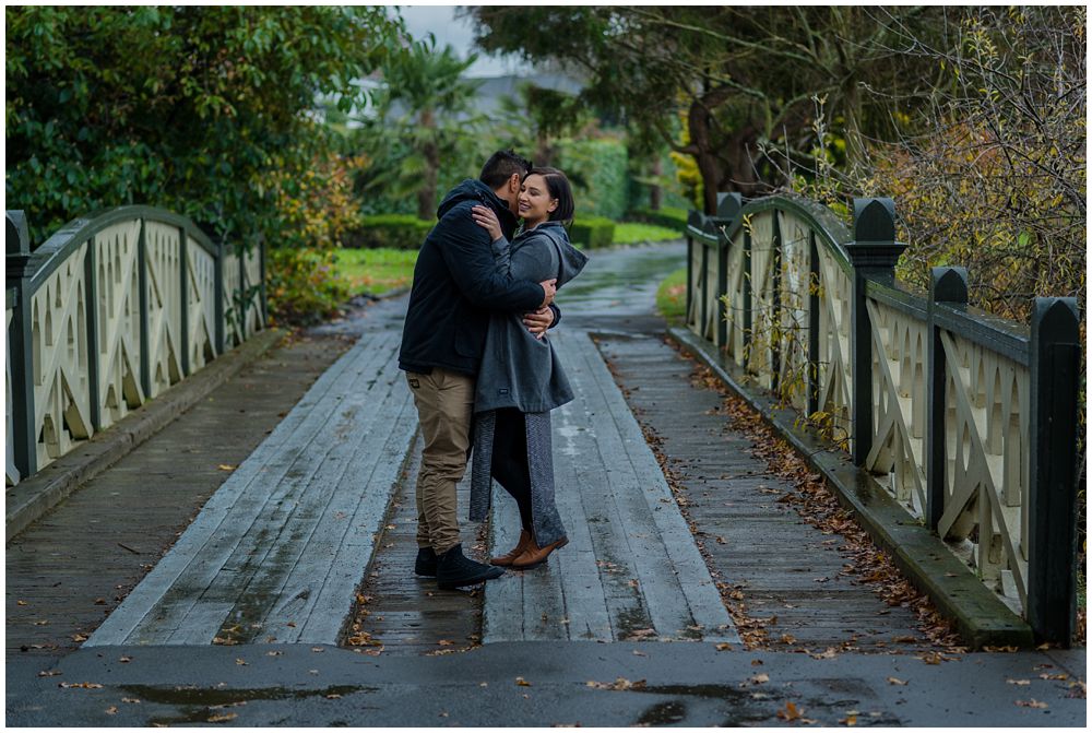 engaged couple standing on a bridge at Mona Vale Gardens