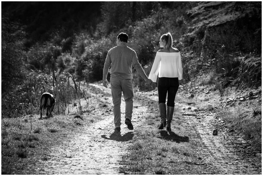 couple and dog walking down a path