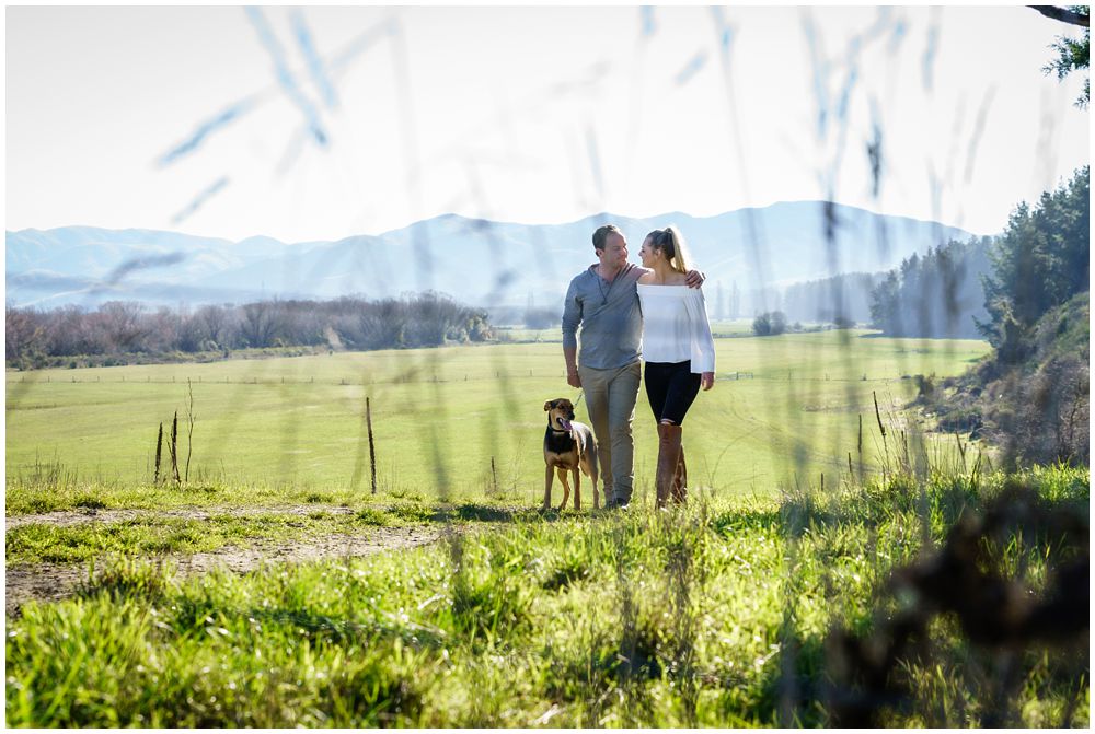 couple and dog with mountain view in the background