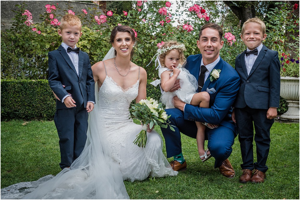 bride and groom pose for a photo with flowergirl and pageboys